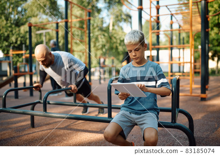 Daddy and boy on exercise machine, sport training Daddy and boy on exercise machine, sport training 83185074