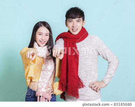 Young couple winter clothes  hand pointing  camera 83185080