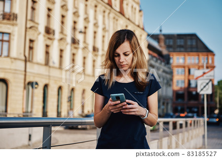 Woman using smartphone at city street 83185527