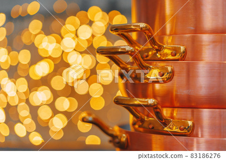 Stack of copper cooking pans on wooden table close up 83186276