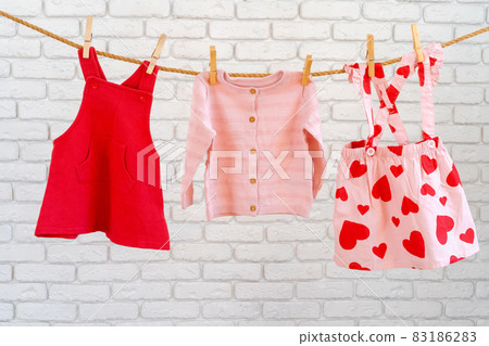 Washing of baby clothes pinned on a rope to dry Washing of baby clothes pinned on a rope to dry 83186283
