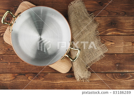 Clean shiny copper kitchenware on wooden board Clean shiny copper kitchenware on wooden board 83186289