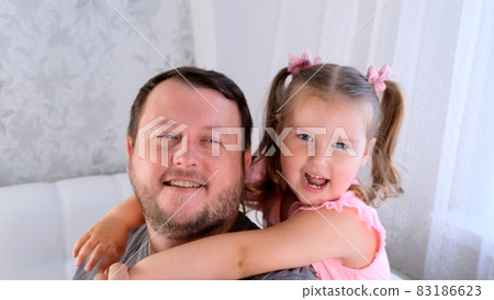 Portrait of laughing dad and daughter, 3 years old, playing at home. Fathers day. Handsome young man Portrait of laughing dad and daughter, 3 years old, playing at home. Fathers day. Handsome young man 83186623