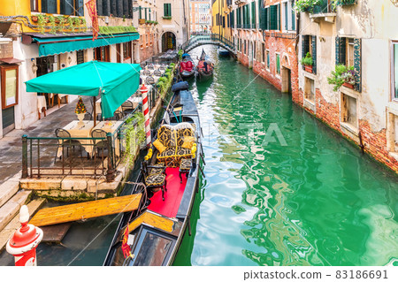 Gondola moored in a narrow street canal of Venice, Italy 83186691