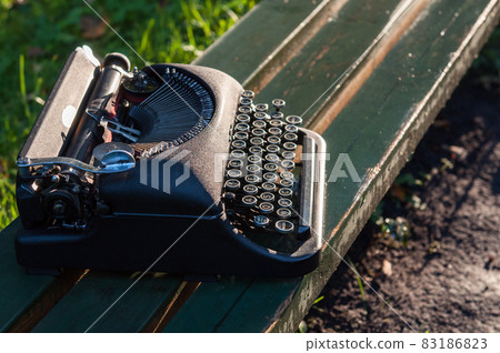 Antique vintage typewriter in on autumn background Antique vintage typewriter in on autumn background 83186823