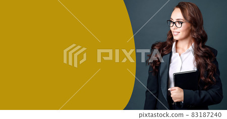 A beautiful Caucasian woman in glasses and a business suit looks away at the empty space and smiles A beautiful Caucasian woman in glasses and a business suit looks away at the empty space and smiles 83187240