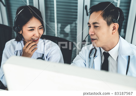Doctor team wearing headset talking actively on video call in hospital clinic Doctor team wearing headset talking actively on video call in hospital clinic 83187567
