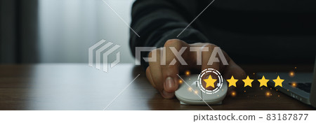 Close up man using mount computer for rating feedback from customer service with annual survey with five gold star icon. Business annual satisfaction survey concept. User reviews and feedback online. 83187877