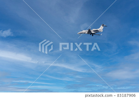 private jet while landing on a blue sky private jet while landing on a blue sky 83187906