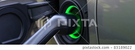 Electric car and charging at charging station closeup Electric car and charging at charging station closeup 83189022
