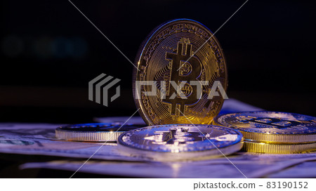 Bitcoin BTC coin and Ethereum ETH coins rotating on bills cash of 100 dollars, virtual money mining Bitcoin BTC coin and Ethereum ETH coins rotating on bills cash of 100 dollars, virtual money mining 83190152