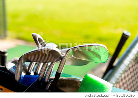 Golf clubs drivers over green field background 83190180