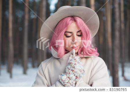 Winter woman looking down outdoors in snow on cold winter day Winter woman looking down outdoors in snow on cold winter day 83190765
