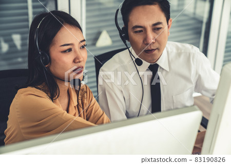 Business people wearing headset working actively in office Business people wearing headset working actively in office 83190826