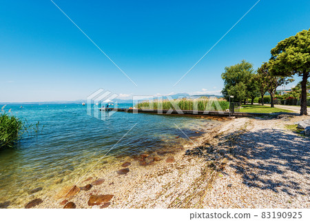 Small Beach with Wooden Pier on the Coast of Lake Garda - Veneto Italy 83190925