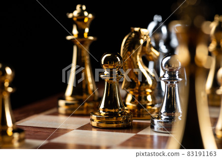 Gold and silver chess figures placed on chessboard 83191163