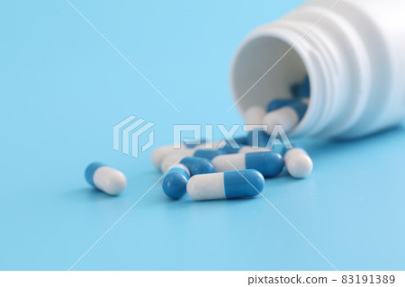 pills capsules with bottle isolated on blue background pills capsules with bottle isolated on blue background 83191389