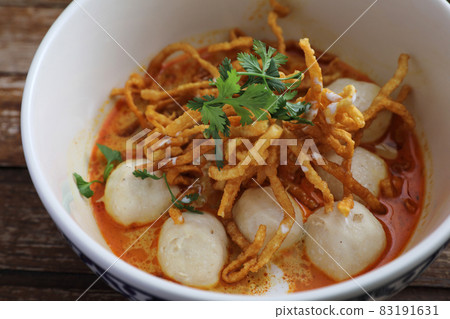 Local northern Thai food Egg noodle curry with meatballs on wood background Local northern Thai food Egg noodle curry with meatballs on wood background 83191631