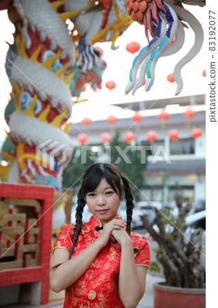 beauty woman wear red cheongsam looking and smile in chinese new year 83192077