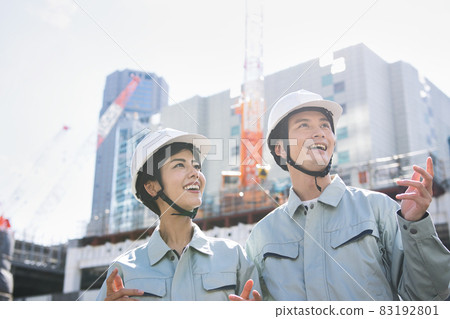 Men and women in work clothes standing at the construction site Men and women in work clothes standing at the construction site 83192801