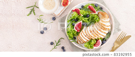 Chicken breast baked and fresh salad of lettuce, arugula, blueberry and figs. Healthy diet food. Top view. Banner. 83192955