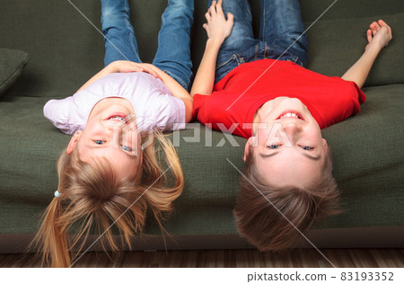 Happy siblings on a sofa Happy siblings on a sofa 83193352