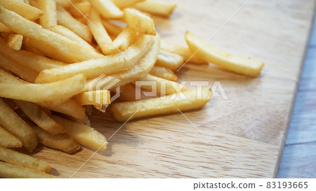 French fries served on a wooden board and copy space on the right 83193665