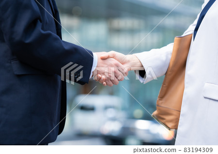 Business person middle handshake at hand Business person middle handshake at hand 83194309