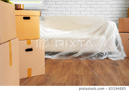 Packed sofa and stack of cardboard boxes in a room. Moving concept 83194885