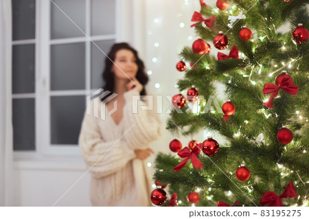 Christmas Tree at Home and Defocused Woman Indoors Christmas Tree at Home and Defocused Woman Indoors 83195275