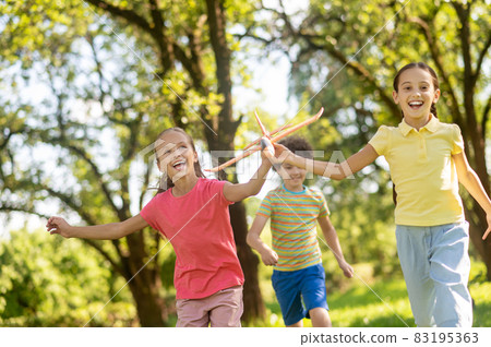 Running two joyful girls with toy and boy 83195363
