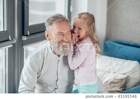 A cute blonde girl sharing secrets with her father 83195548