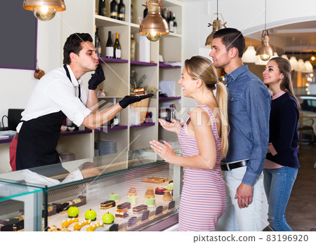 Two women and man are choosing delicious cakes from showcase Two women and man are choosing delicious cakes from showcase 83196920