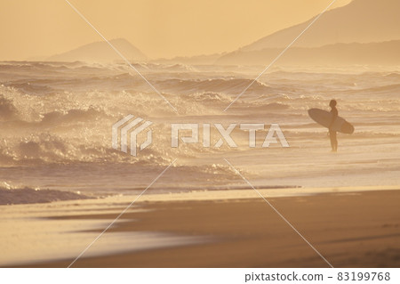 Atsumi Peninsula, a surfer standing in the evening view of the Omotehama coast Atsumi Peninsula, a surfer standing in the evening view of the Omotehama coast 83199768
