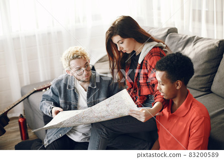 Group of diverse friends looking at map in the bright room Group of diverse friends looking at map in the bright room 83200589
