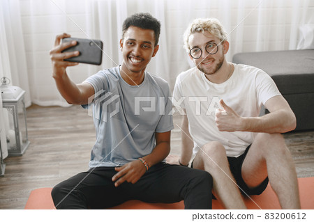 Two male friends taking selfie after home workout Two male friends taking selfie after home workout 83200612