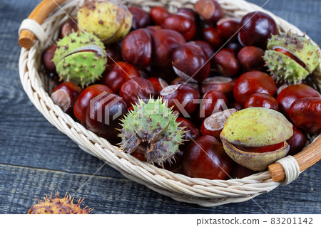 Chestnuts in a basket on a wooden background 83201142