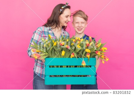 Family portrait sister and teenager brother with tulips on pink background 83201832