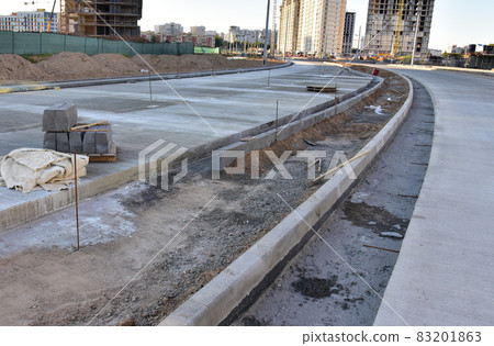Installation of concrete curbs during road construction.  83201863