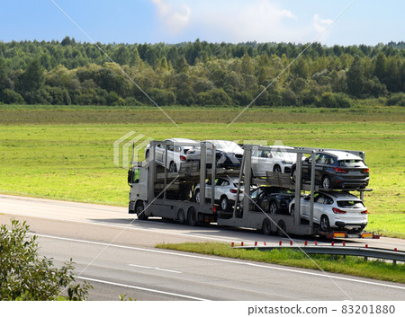 Car carrier trailer transports cars on highway. Car carrier trailer transports cars on highway. 83201880