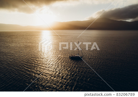 The yacht sails on the ocean at sunset. The yacht sails on the ocean at sunset. 83206789