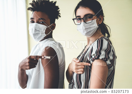 Diverse group of people showing COVID-19 vaccine bandage merrily 83207173