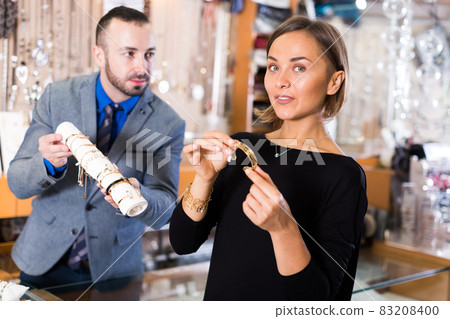 Positive female consumer trying bracelet Positive female consumer trying bracelet 83208400