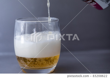 Beer that shines on a gray background Beer poured into a glass Beer that shines on a gray background Beer poured into a glass 83208622