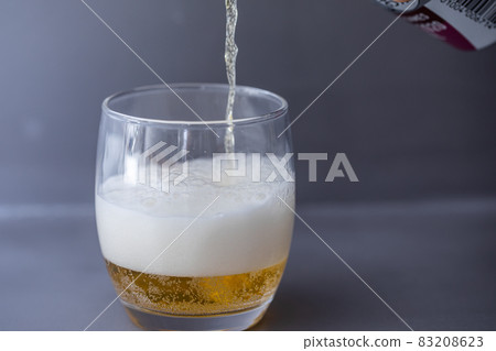 Beer that shines on a gray background Beer poured into a glass Beer that shines on a gray background Beer poured into a glass 83208623