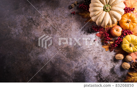 Autumn composition. Pumpkin, autumn leaves and apple on dark stone background. Flat lay, top view with copy space. Autumn composition. Pumpkin, autumn leaves and apple on dark stone background. Flat lay, top view with copy space. 83208850