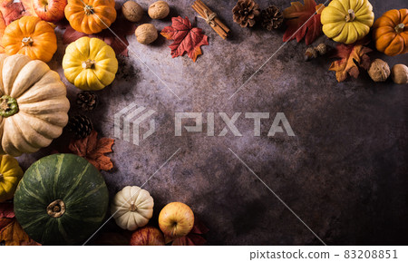 Thanksgiving background concept with fall leaves, pumpkin and seasonal autumnal decor on dark stone background. Thanksgiving background concept with fall leaves, pumpkin and seasonal autumnal decor on dark stone background. 83208851