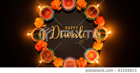 Happy Diwali - Clay Diya lamps lit during Dipavali, Hindu festival of lights celebration. Colorful traditional oil lamp diya on black background Happy Diwali - Clay Diya lamps lit during Dipavali, Hindu festival of lights celebration. Colorful traditional oil lamp diya on black background 83208853