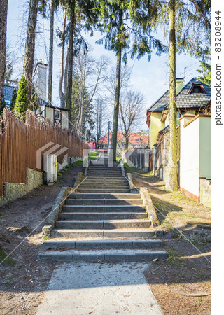 A stone staircase in the town among cosy cottages and pine trees A stone staircase in the town among cosy cottages and pine trees 83208944