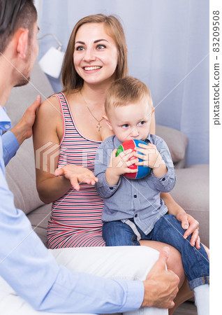 Smiling mother and father with little son talking Smiling mother and father with little son talking 83209508